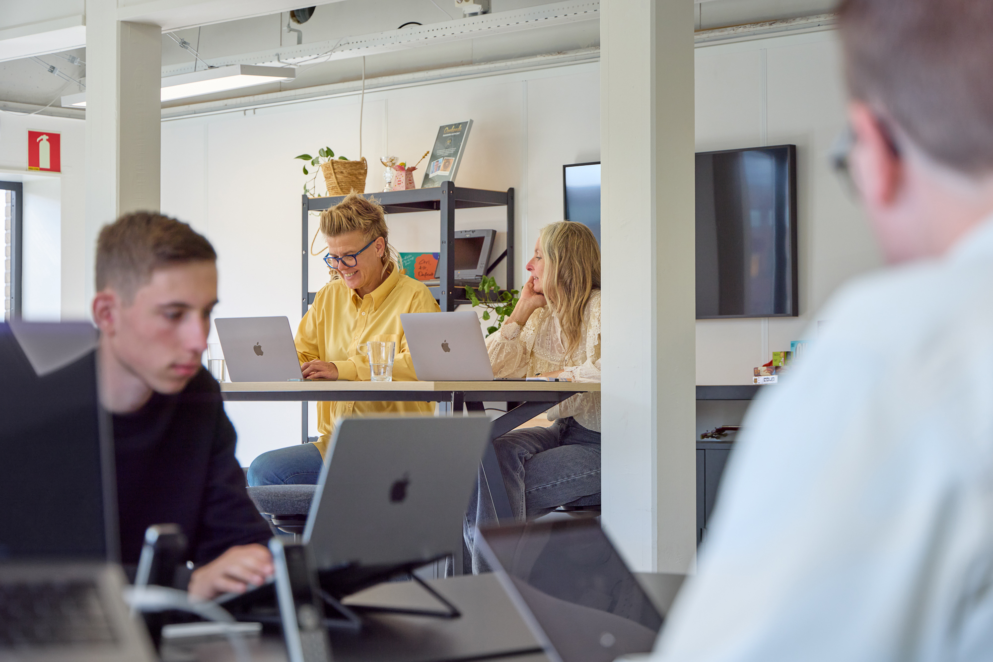 Sfeerfoto van de werksfeer binnen Foster: twee medewerkers overleggen aan de bar